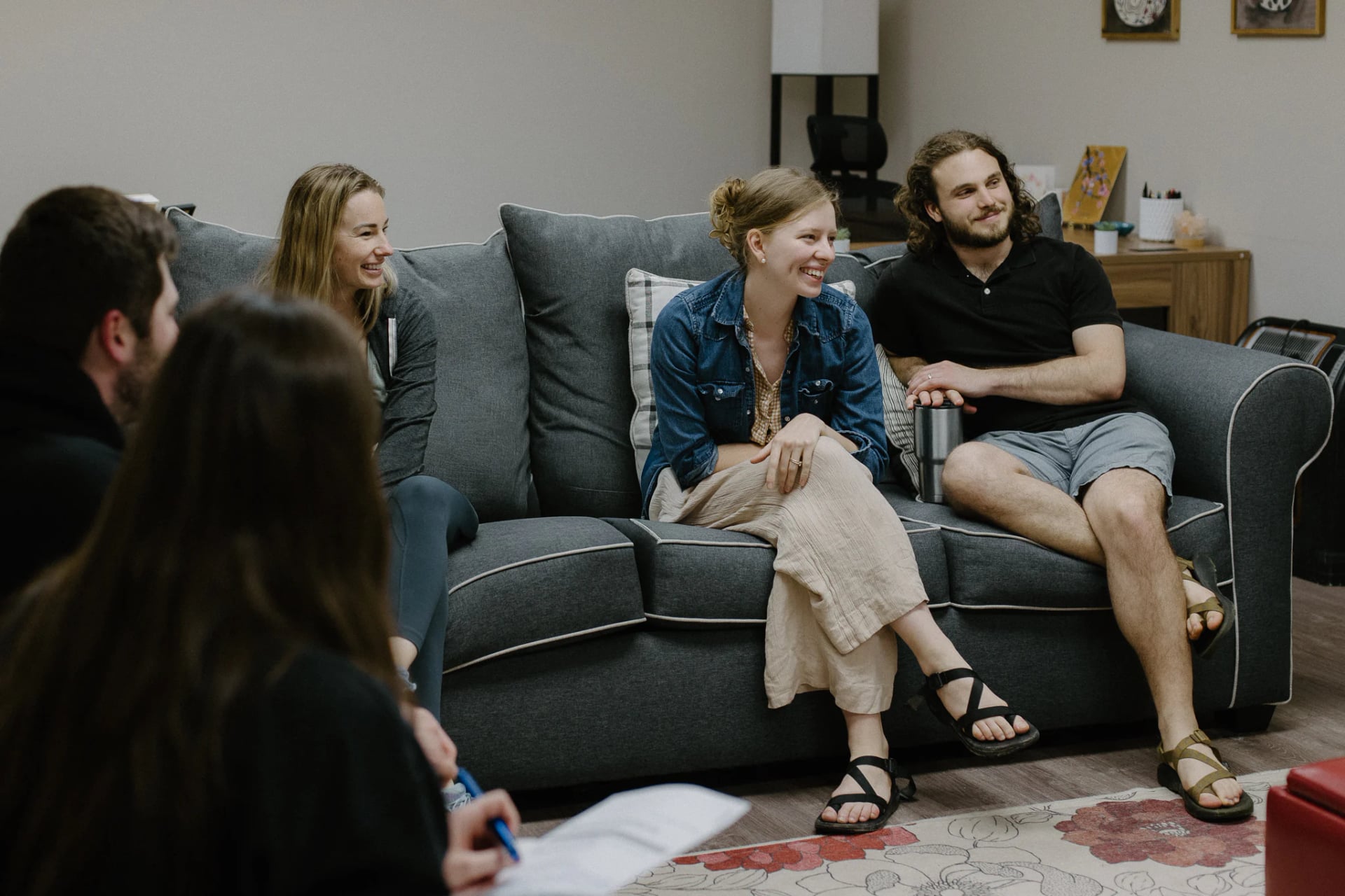 A community group laughing together on a couch